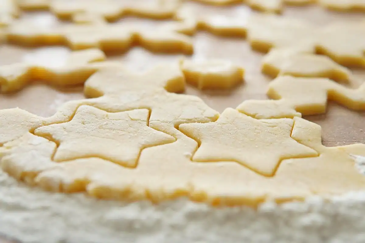 Aluat întins și decupat în forme de stele pentru biscuiți făcuți împreună