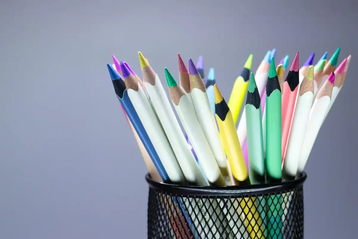 Creioane colorate și materiale pentru desen, pe o masă de lucru creativ